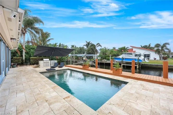 HUGE deck features gorgeous pool, large dock, TWO boat lifts AND an outdoor kitchen!