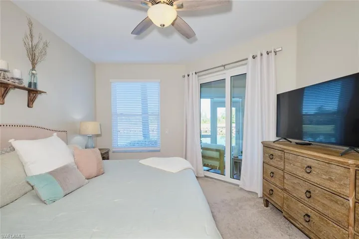 Carpeted bedroom featuring access to exterior and ceiling fan