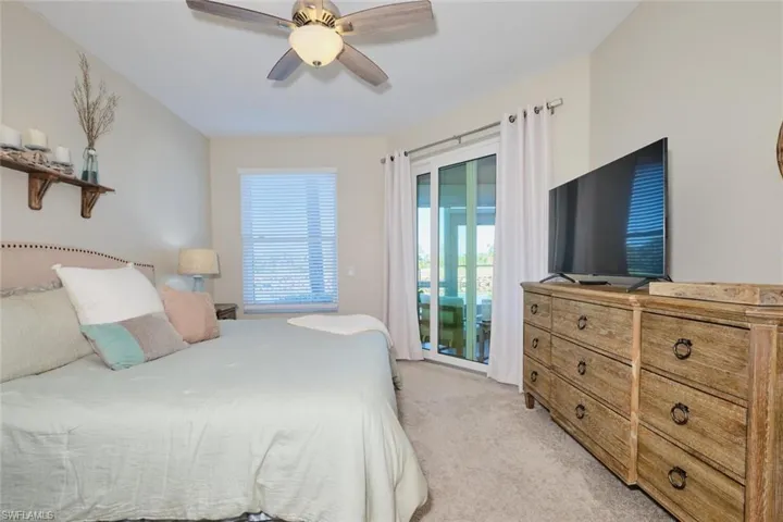 Carpeted bedroom with access to outside and ceiling fan