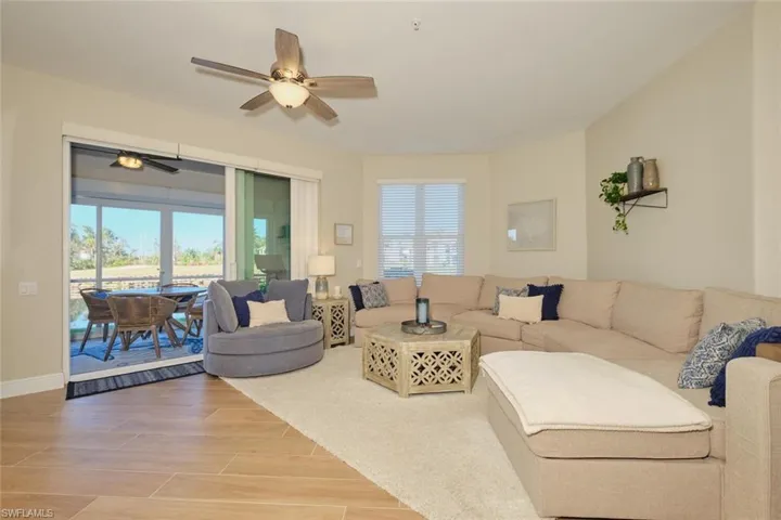 Living room featuring hardwood / wood-style floors, ceiling fan, and a healthy amount of sunlight