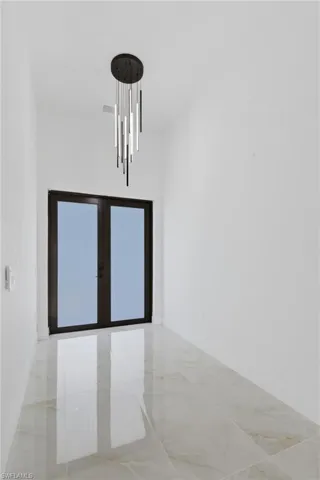 Empty room with french doors and baseboards