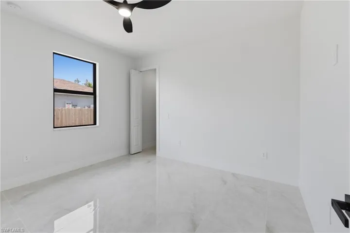 Spare room featuring ceiling fan and baseboards