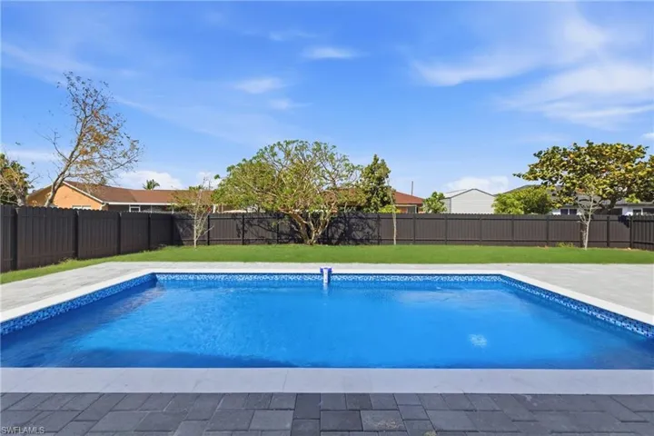 View of swimming pool featuring a fenced backyard and patio surround