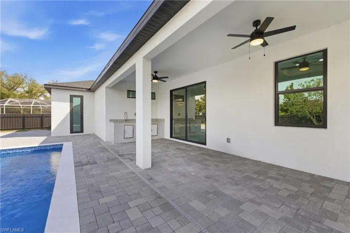 View of pool with patio surround and area for grilling