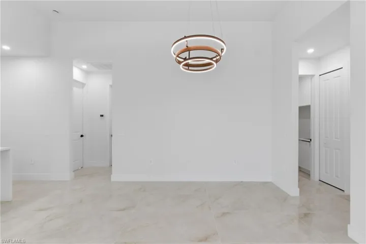Spare room featuring hanging lights and baseboards