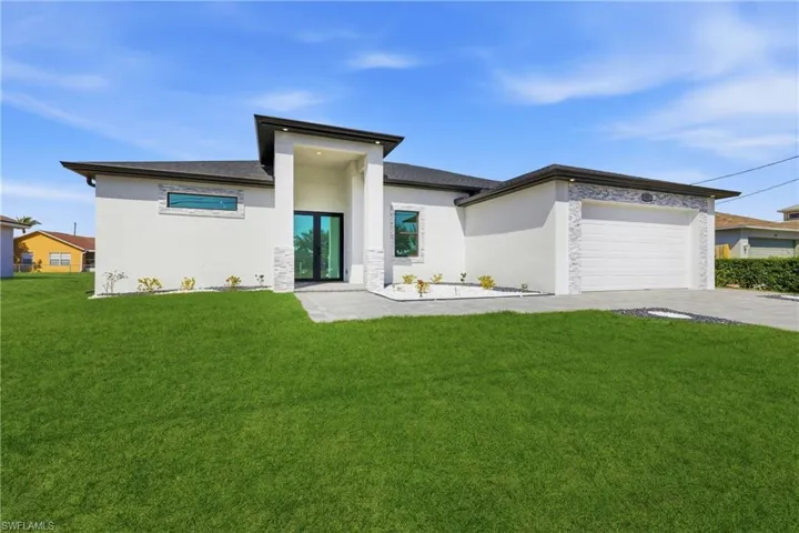 View of front of property with a front lawn, an attached garage, and stucco siding