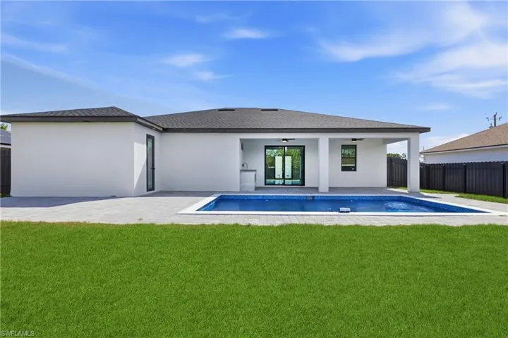 Back of house featuring a fenced backyard, ceiling fan, a patio, and roof with shingles