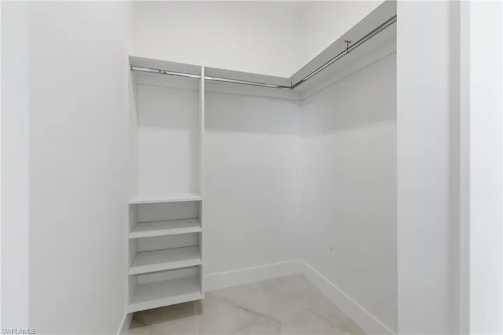 Walk in closet with light tile patterned floors