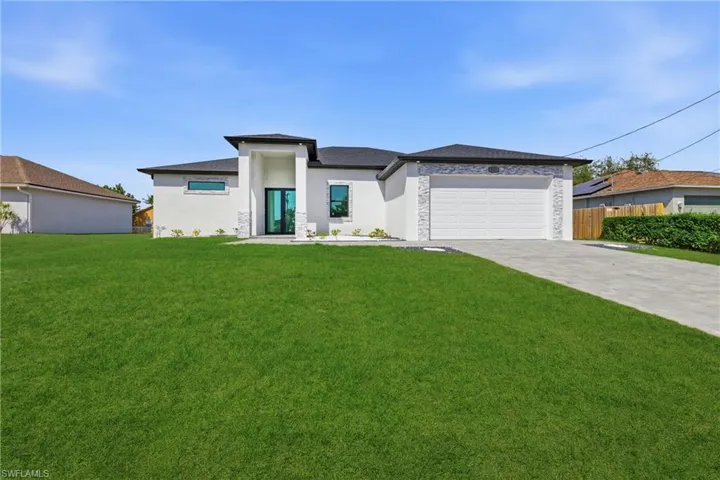 Prairie-style home featuring driveway, an attached garage, and stucco siding