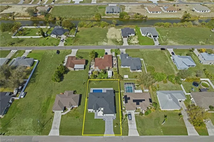 Aerial view of residential area featuring property parcel outlined and a large body of water