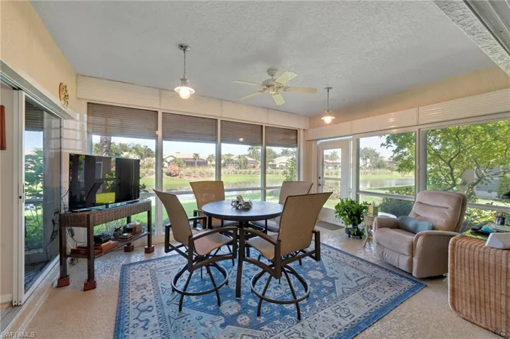Sunroom featuring a water view and ceiling fan