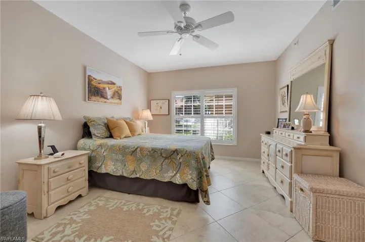 Tiled bedroom featuring ceiling fan