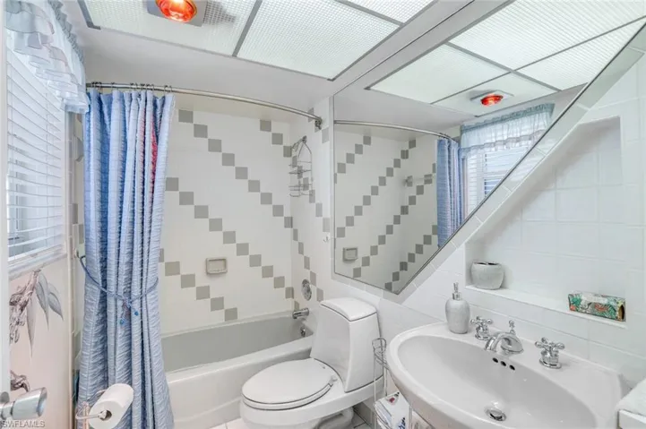 Full bath with tile walls, shower / tub combo, and vanity