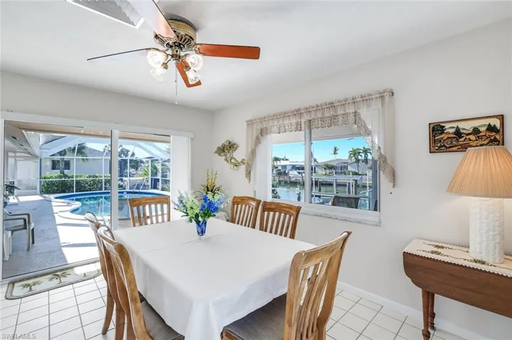 Dining area with a sunroom, ceiling fan, and light tile patterned floors