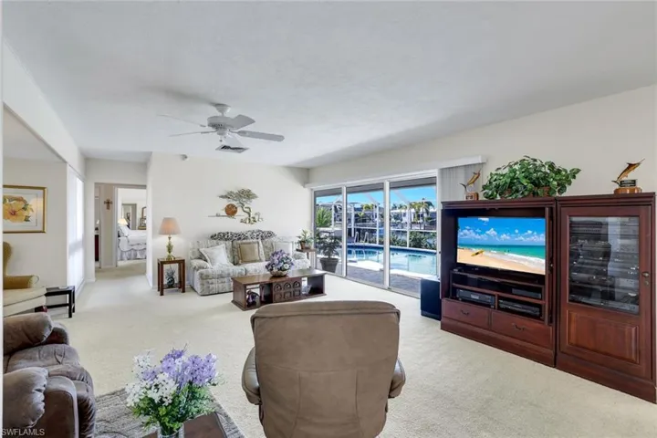 Carpeted living area with a ceiling fan