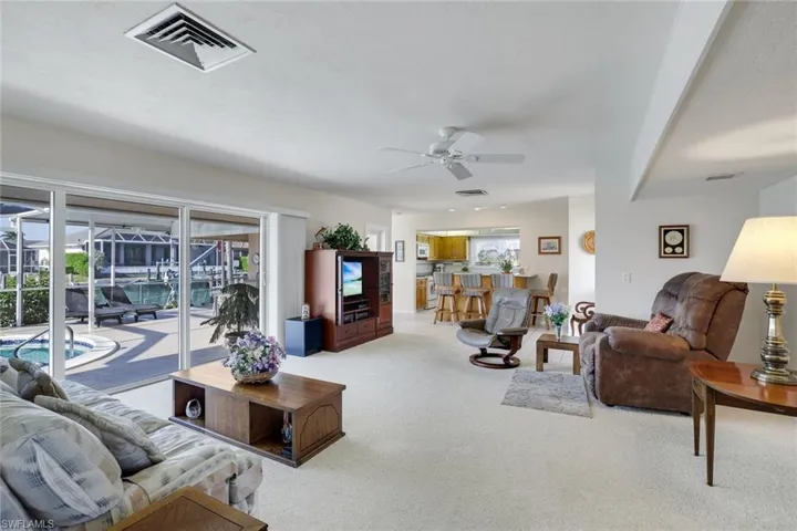 Living area featuring ceiling fan and carpet flooring