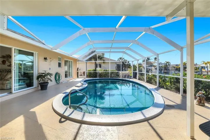 Outdoor pool with a lanai, a patio, and a sunroom