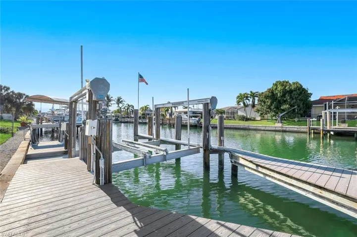 Dock featuring boat lift and a water view