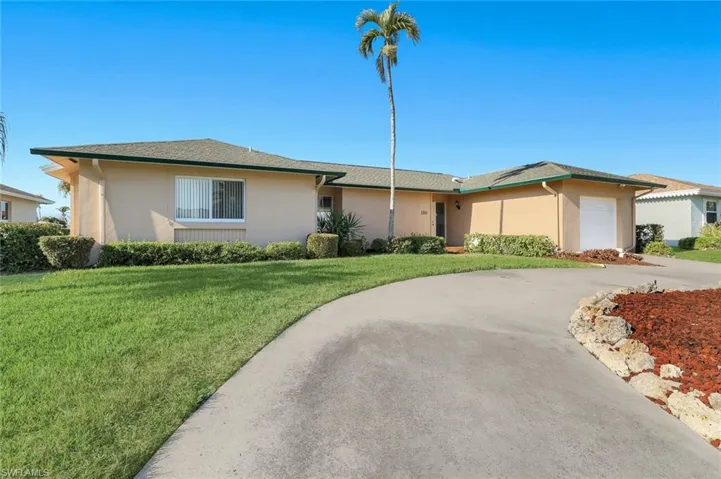 Single story home featuring a front yard, stucco siding, driveway, and a garage