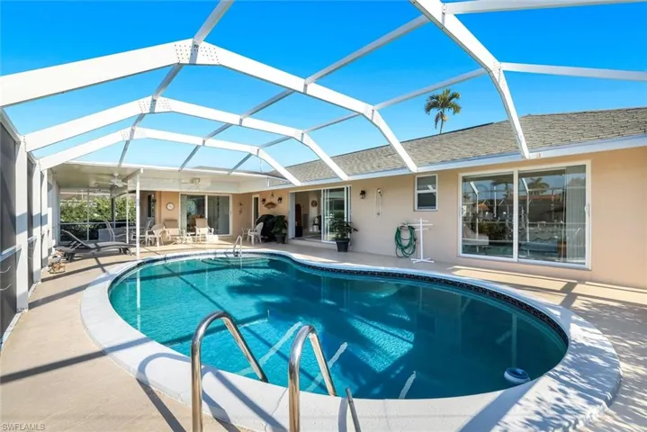 Swimming pool with a lanai, a sunroom, and a patio area