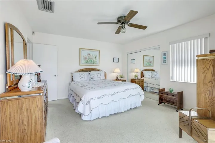 Carpeted bedroom featuring ceiling fan and a closet