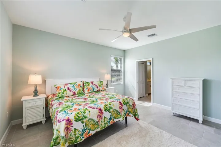 Tiled bedroom featuring ceiling fan