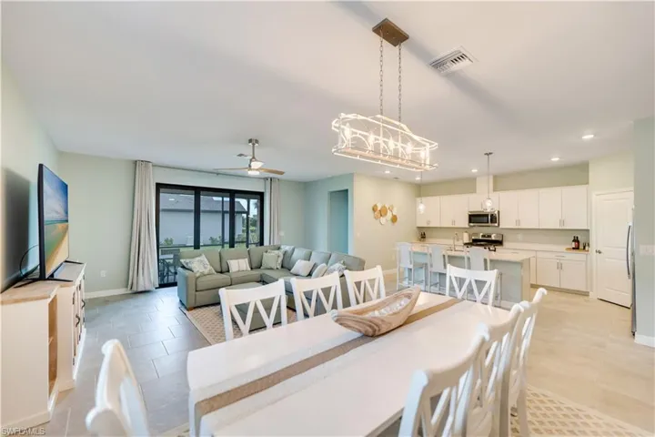 Dining space with light tile patterned floors and ceiling fan