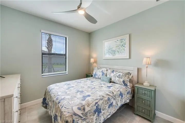 Tiled bedroom featuring ceiling fan