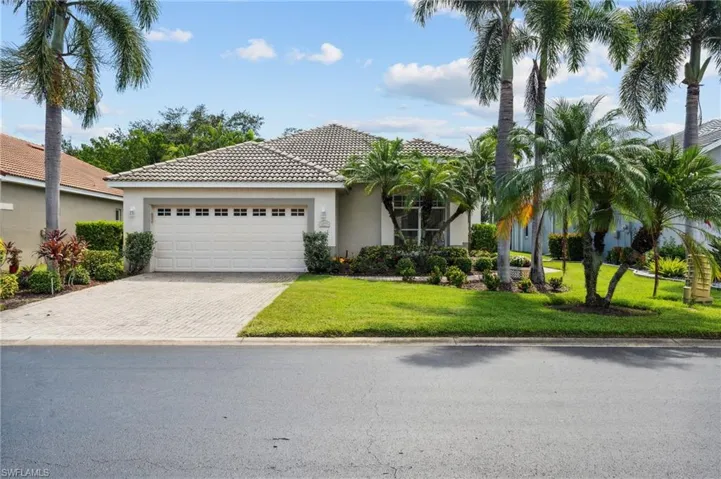 Mediterranean / spanish home with a garage and a front lawn