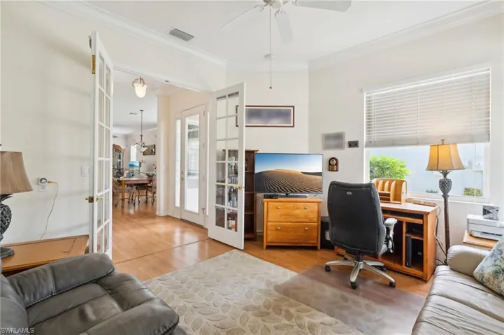 Home office with light wood-type flooring, french doors, plenty of natural light, and ceiling fan