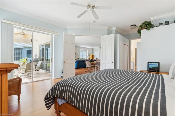 Bedroom with crown molding, wood-type flooring, and access to outside