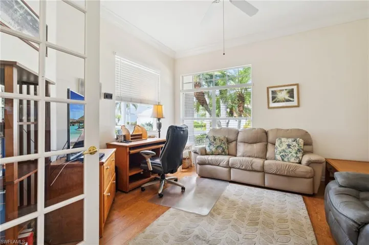 Office space featuring ceiling fan, ornamental molding, and light wood-type flooring