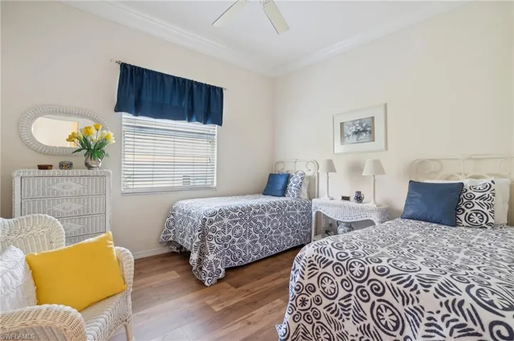 Bedroom featuring hardwood / wood-style floors, ceiling fan, and ornamental molding