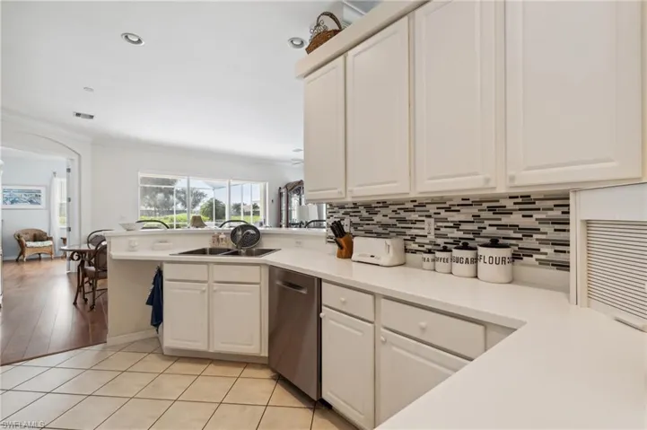 Kitchen featuring dishwasher, crown molding, light hardwood / wood-style flooring, and sink