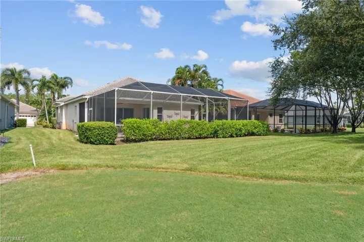 Rear view of property featuring glass enclosure and a yard