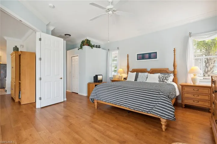 Bedroom featuring ornamental molding, light hardwood / wood-style flooring, ceiling fan, and a closet