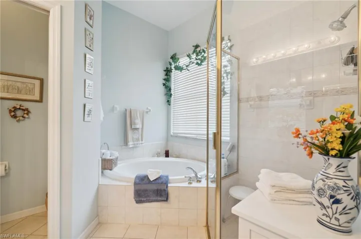 Full bathroom featuring plus walk in shower, tile patterned flooring, toilet, and vanity