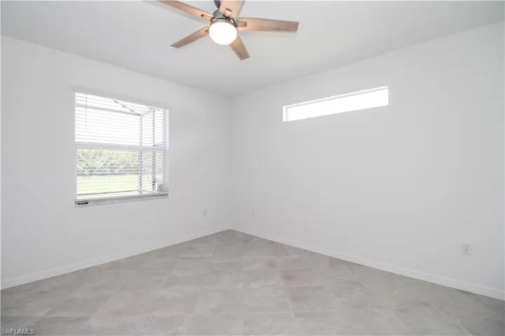 Tiled spare room with ceiling fan and a wealth of natural light