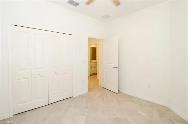 Unfurnished bedroom featuring a closet, ceiling fan, and light tile patterned floors