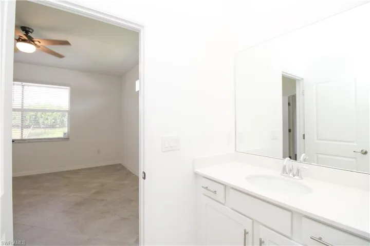 Bathroom with vanity, tile patterned floors, and ceiling fan