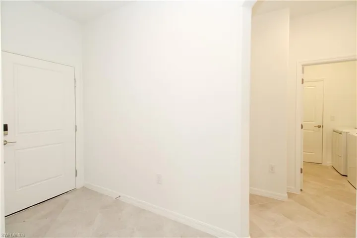 Tiled spare room featuring washing machine and clothes dryer