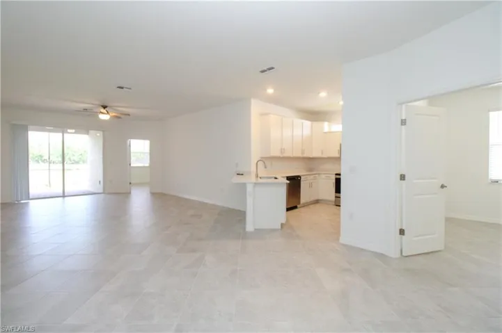 Kitchen with dishwasher, kitchen peninsula, ceiling fan, and light tile patterned floors