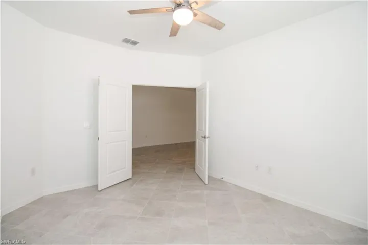 Tiled empty room with ceiling fan