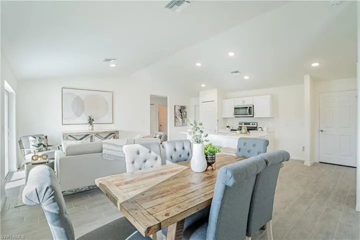Dining room featuring wood tiled floors, lofted ceiling, and recessed lighting