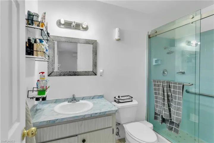 Full bathroom with toilet, a stall shower, and vanity