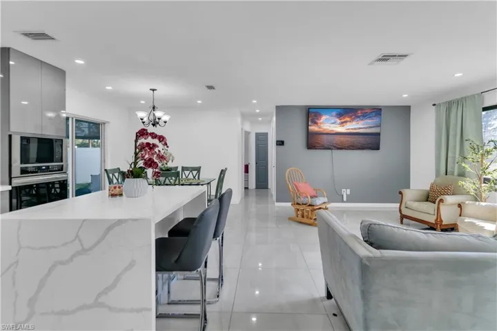 Kitchen with a notable chandelier, visible vents, stainless steel oven, modern cabinets, and built in microwave