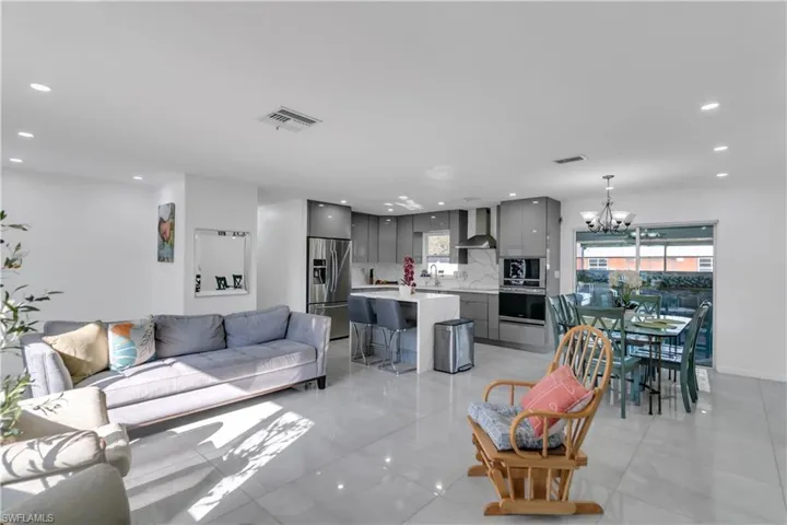 Living area with an inviting chandelier, visible vents, and recessed lighting
