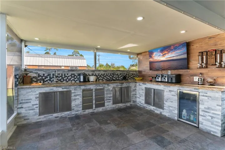 View of patio with exterior kitchen, wine cooler, and a sink