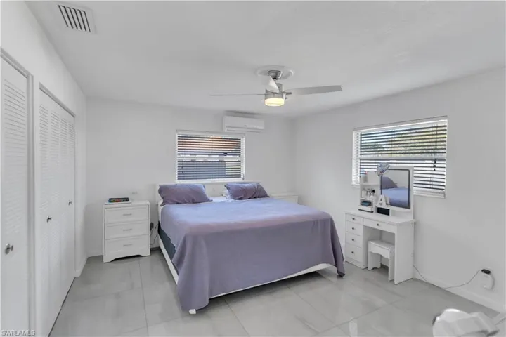 Bedroom featuring a ceiling fan, visible vents, and a wall unit AC