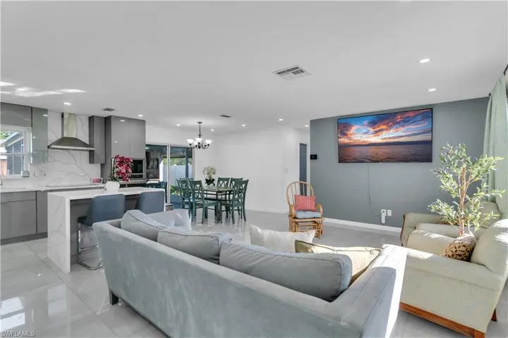 Living room with baseboards, visible vents, a chandelier, and recessed lighting